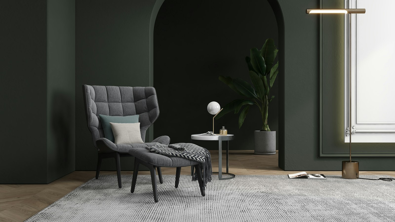A grey armchair and ottoman with a knit throw in a dark green room
