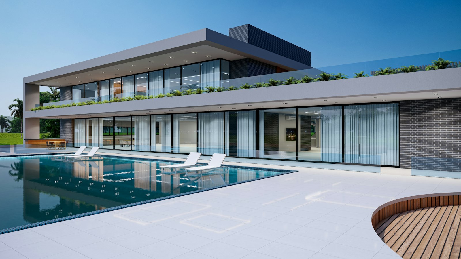 A modern glass house beside a long pool under a clear sky
