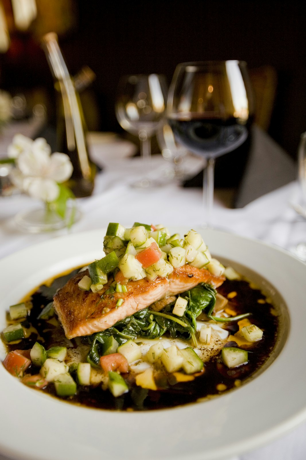 Seared salmon with a bright herb salsa and a glass of red wine