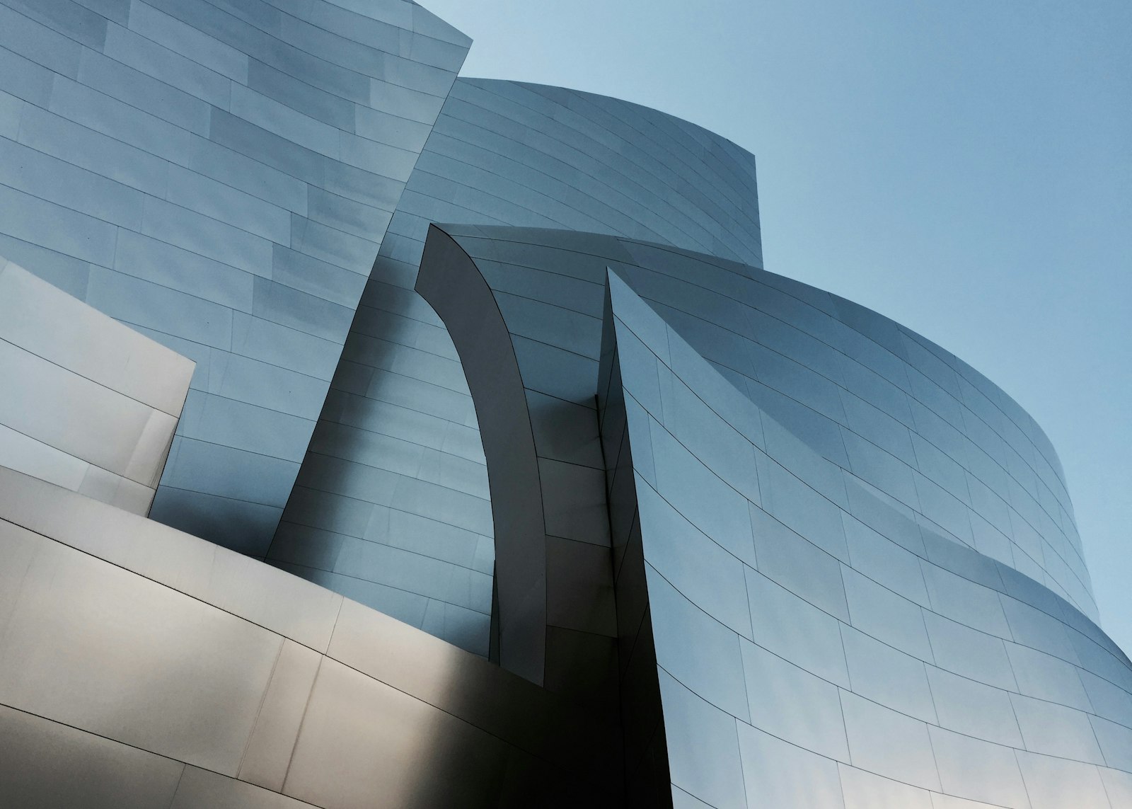 Curved stainless steel panels of the Walt Disney Concert Hall against a blue sky