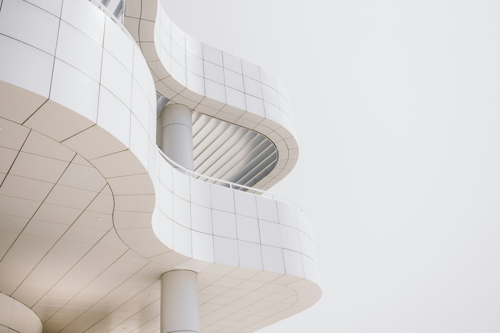 A white tiled building facade with curved balconies